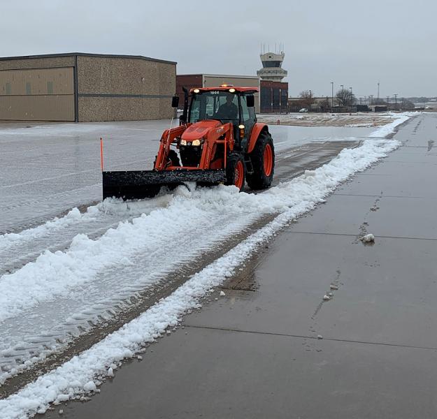 Plow removing ice on an airport runway