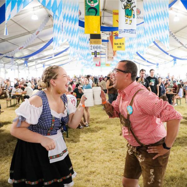 Couple in traditional German clothing toasting