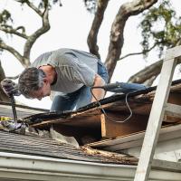 man repairing wood and roof