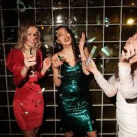 3 women celebrating nye in party attire