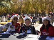 3 ladies sitting in Santa hats and seasonal sweaters