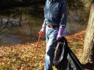 Man walking through the park picking up trash