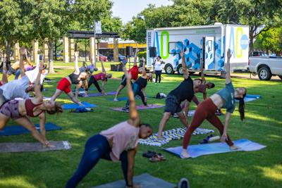 People doing yoga in front of the Addison Outdoors trailer