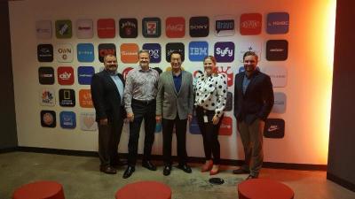 Group of people in front of a wall of business logos