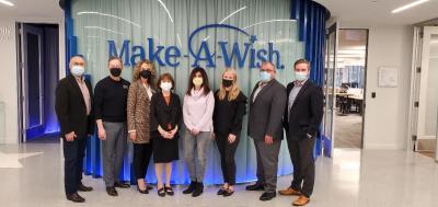Group of People standing in front of Make A Wish wall sign