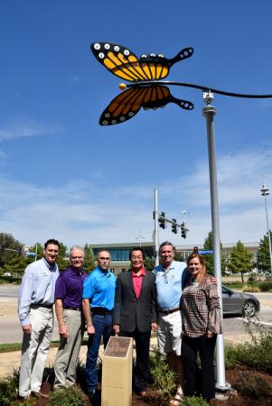 Group of people standing under the butterfly statue
