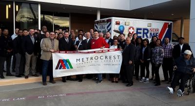 group of people holding Metrocrest Chamber banner and a ribbon