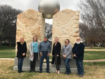 Addison Arbor Foundation Board Members and Addison Parks staff in front of a stone and metal sculpture called Arcadia