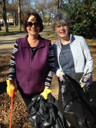 Two women helping out with picking up garbage at a park