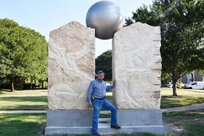 Man standing in front of large stone sculpture