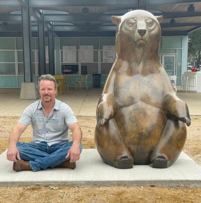 Colorado artist Joshua Tobey with Mediation, a 5-foot-tallbear sitting in a lotus position in Addison Circle Park