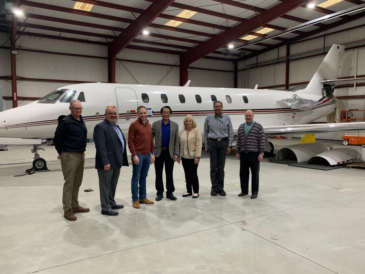 Group of business people standing in front of a business jet