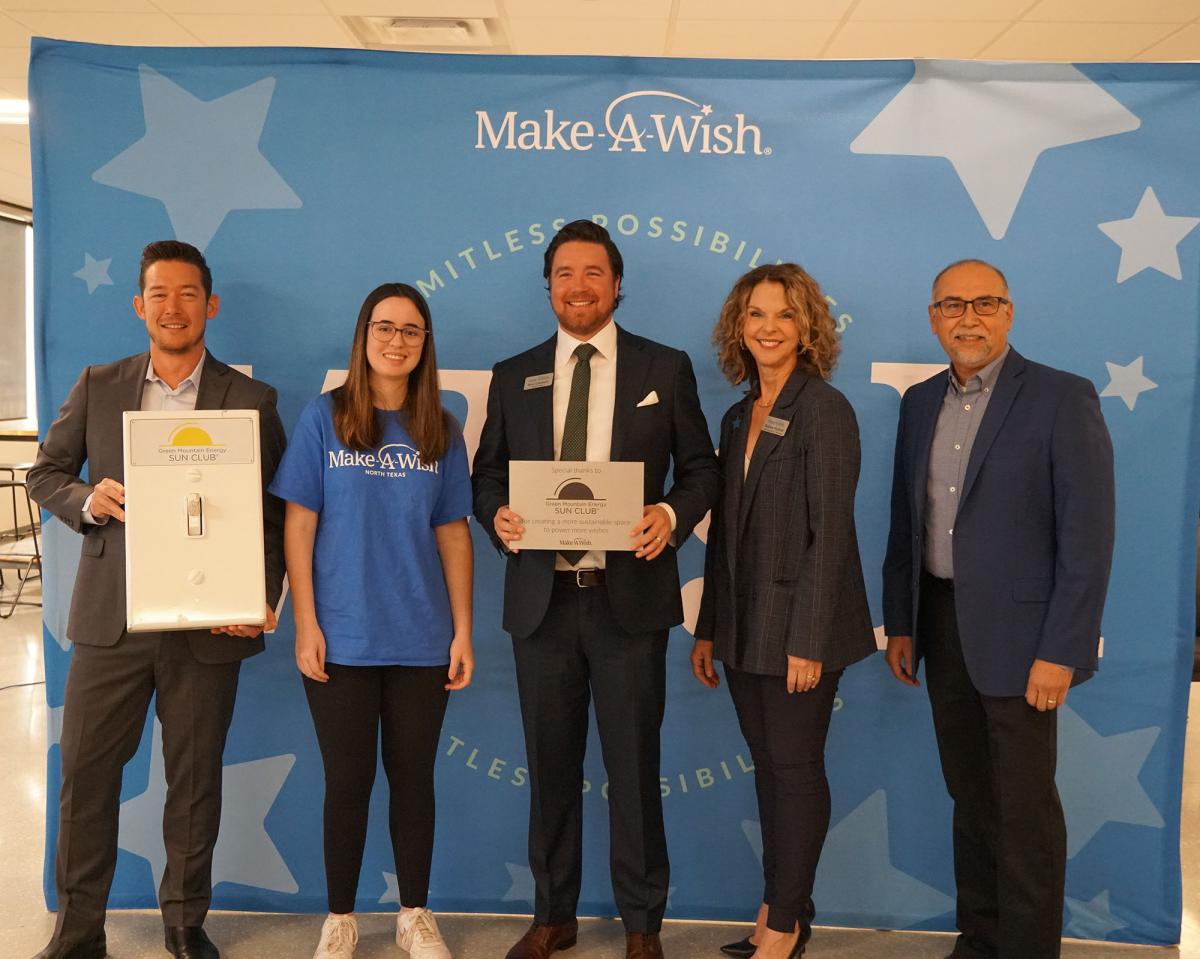 Group of adults standing in front of Make a Wish back drop