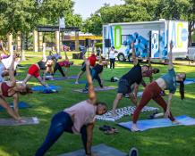 People doing yoga in front of the Addison Outdoors trailer